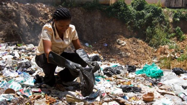 A UN representative picks out polythene bags from a dump site near the Old Town of Mombasa (05 February 2013)