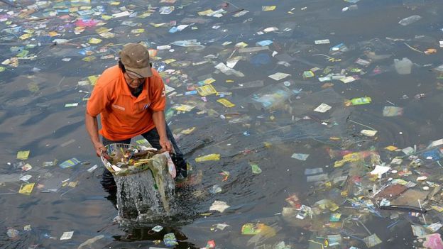 Homem coleta plástico das águas do mar nas Filipinas