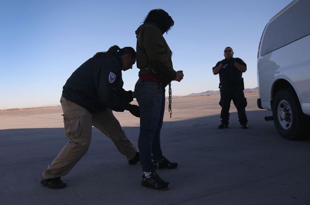 Una agente de seguridad revisa a una Inmigrante indocumentada a punto de ser deportada a Honduras.
