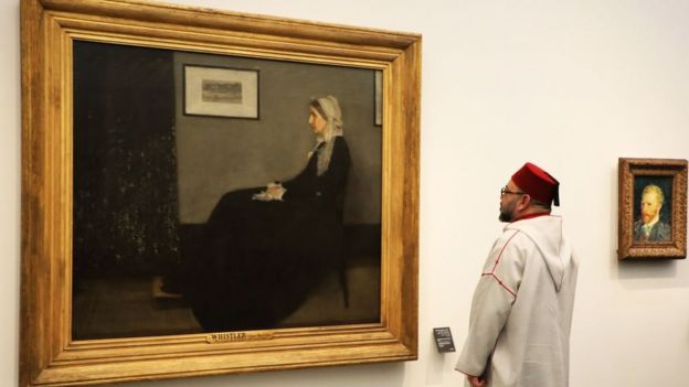 Moroccan King Mohammed VI looks at a painting titled 'Whistler's Mother' by James Abbott McNeill Whistler (1871) as he visits the Louvre Abu Dhabi Museum during its inauguration on November 8, 2017 on Saadiyat island in the Emirati capital