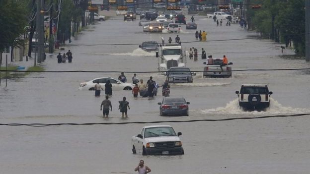 Personas dejan sus autos tras las inundaciones