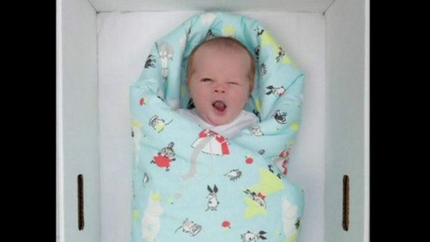 Criança recém-nascida dentro de caixa