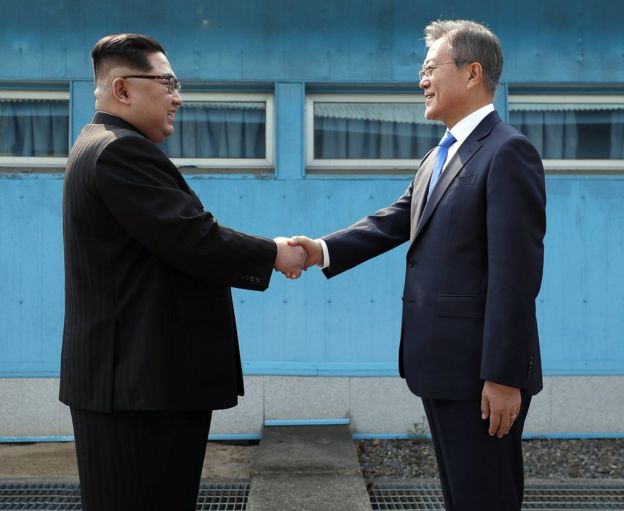 North Korean leader Kim Jong-un (left) and South Korean President Moon Jae-in pose for photos in front of Peace House in Panmunjom, South Korea, 27 April 2018