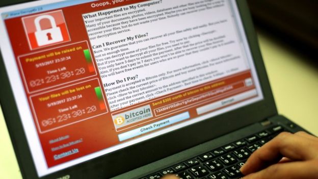 A programmer shows a sample of the WannaCry locked encryption page on a laptop