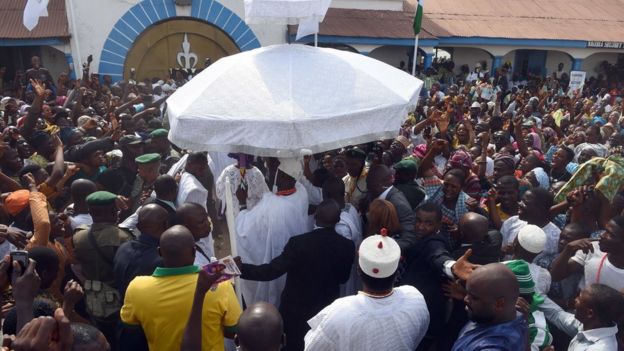 Adeyeye Enitan Ogunwusi under an umbrella