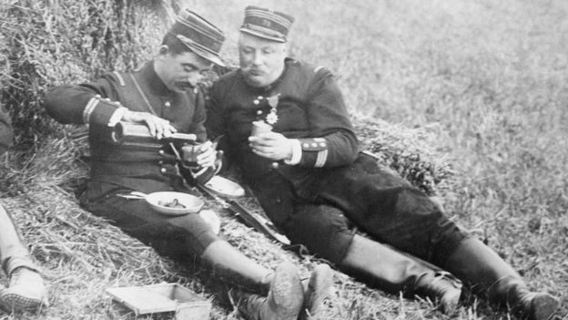 Dos soldados comiendo en el campo, en una foto en blanco y negro