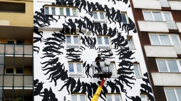 The artist David de la Mano works on his street art painting on the outskirts of a residential house near the Museum for Urban Contemporary Art in Berlin (15 September 2017)