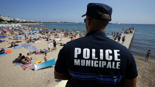 Un policía mira a las personas en una playa de Francia.