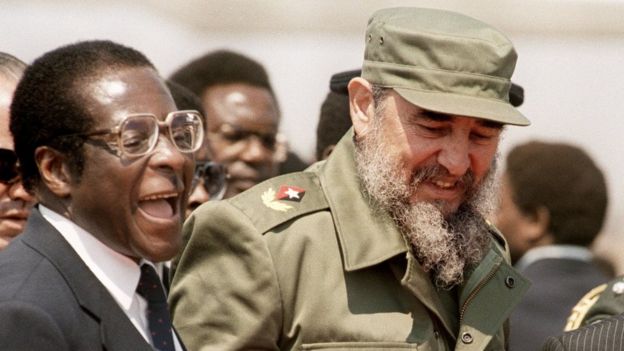 Robert Mugabe laughs as he stands next to Fidel Castro