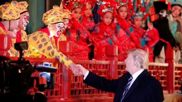 US President Donald Trump shakes hands with an opera performer in Beijing