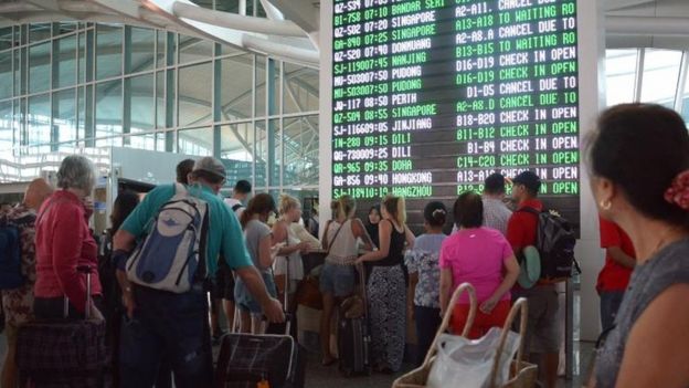 Passengers watch the information board at Bali