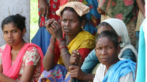 Women tea workers listen as an unseen NGO worker speaks