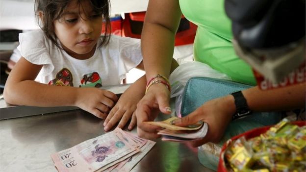 Mulher faz pagamentos em moeda local em supermercado de Caracas