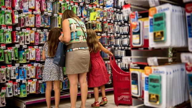 Una mujer con dos niños en una tienda.