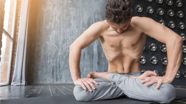 Hombre haciendo yoga mostrando su rectus abdominis