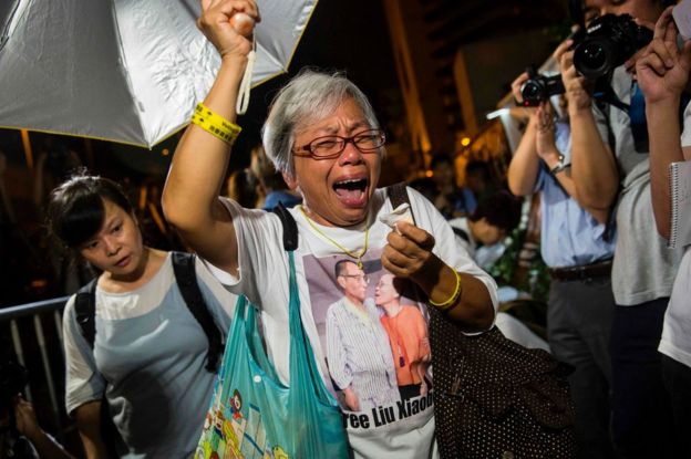 A protester reacts after paying her respects outside the Chinese Liason Office of Hong Kong after the death of Chinese Noble laureate Liu Xiaobo, in Hong Kong on 13 July 2017