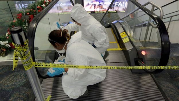 Workers clean the escalators that lead to the baggage claim area at terminal 2 at the Fort Lauderdale-Hollywood International Airport in Fort Lauderdale