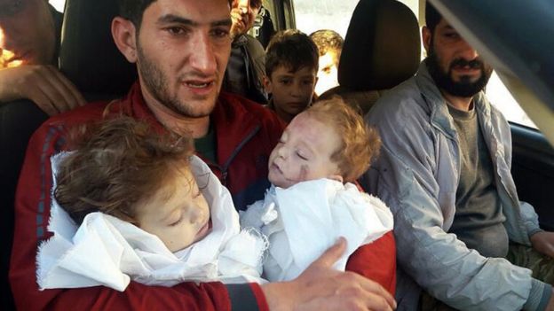 صورة للأب السوري وهو يحمل طفليه المتوفيين