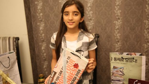 Zymal Umer holds up one of the bags she has made