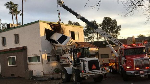 Rescue workers remove a car that crashed into a building after speeding into a median and going airborne, according to local media, in Santa Ana, California, U.S., January 14, 2018,