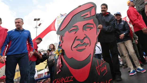 Maduro posa junto a una enorme figura de cartón de Chávez.