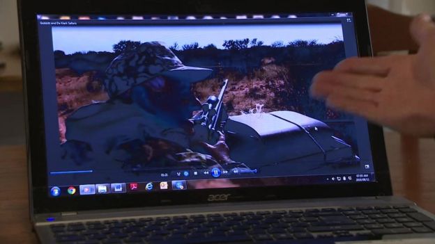 activist points to computer screen displaying footage of hunter in a jeep