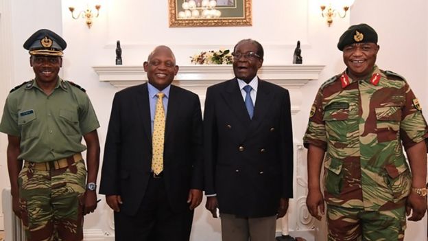 Mugabe (segundo de der. a izq.), que está bajo arresto domiciliario, posa para la foto con el combandante de las Fuerzas de Defensa de Zimbabue, general Constantino Chiwenga (der.)
