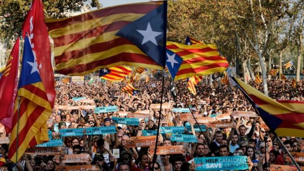 Pro-independence supporters wave flags outside the Catalan regional parliament