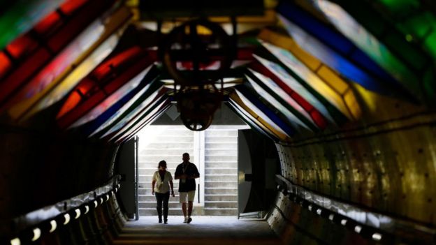 Una pareja camina por un túnel,
