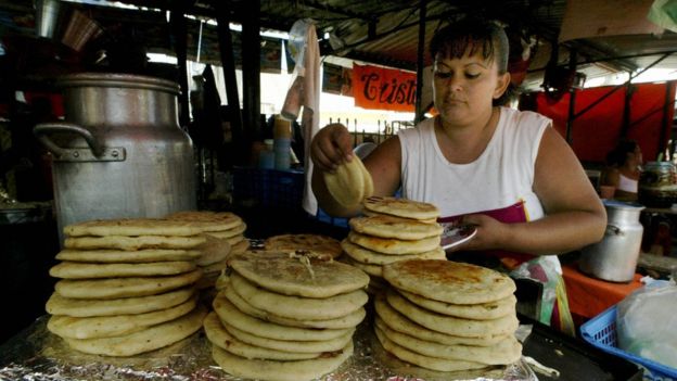 Mujer haciendo pupusas en El Salvador