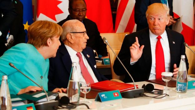 U.S. President Donald Trump talks to German Chancellor Angela Merkel and Tunisia's President Beji Caid Essebsi