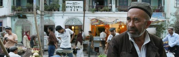 An Uighur man minding a fruit stand in Kasghar, file pic from 2003