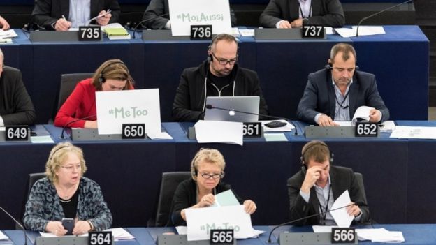 Members of the European Parliament display 'me too' signs