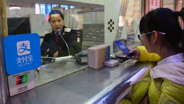 A student pays her travel fare using Alibaba's Alipay app