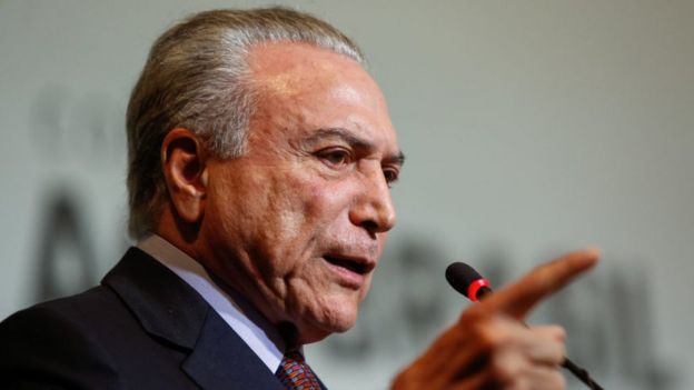 Presidente Michel Temer fala em um púlpito, com o dedo em riste