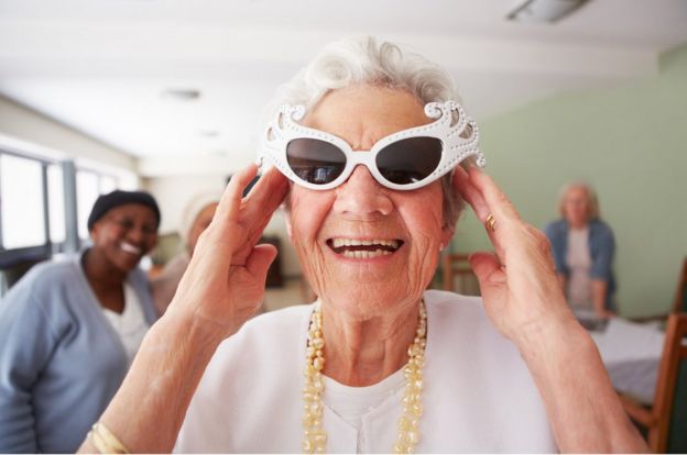 Mulher idosa com óculos de sol sorrindo