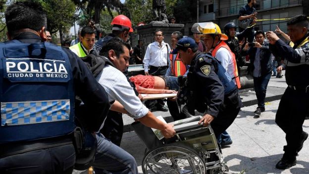 A woman is assisted after being injured during a quake in Mexico City