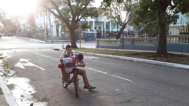 Dos niños paseando en una bicicleta.