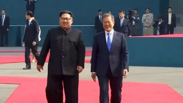 Screengrab of Reuters feed of Kim Jong-un and Moon Jae-in walking on the red carpet to Peace House