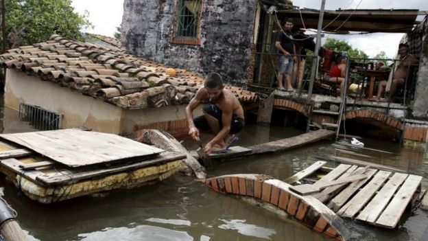 A man works near partially submerged houses in Asuncion, Paraguay. Photo: 20 December 2015