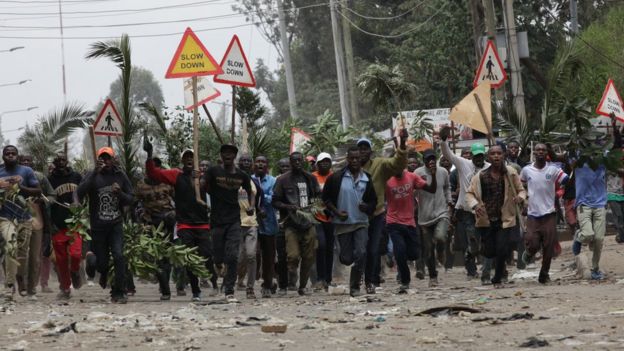 Opposition protesters carry branches and signs in Nairobi