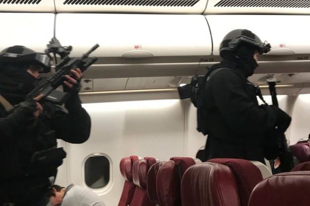 Heavily armed police enter the plane after it returned to Melbourne Airport