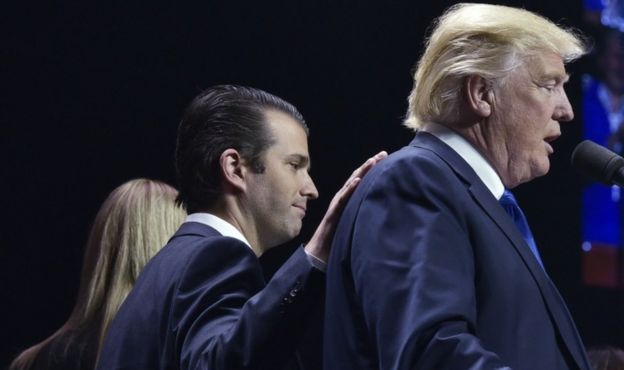 Donald Trump, Jr places a hand on the shoulder of his father, Donald Trump, during a rally on the final night of the 2016 US presidential election