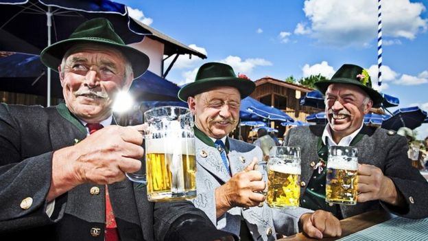 Un grupo de alemanes con trajes tradicionales, bebiendo cerveza