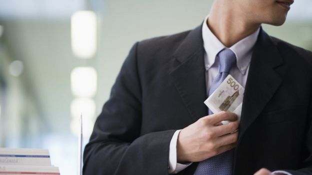 hombre de traje robando dinero