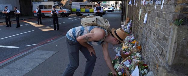 Man leaving flowers close to scene of attack