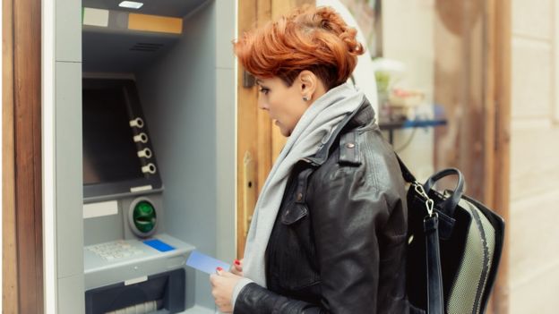 Mujer sacando dinero en un cajero