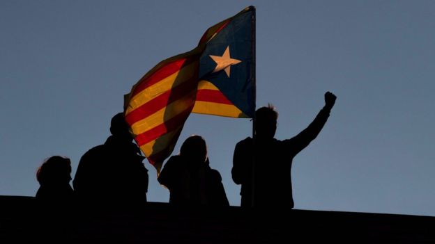 Manifestantes en Barcelona elevando la bandera de Cataluña.