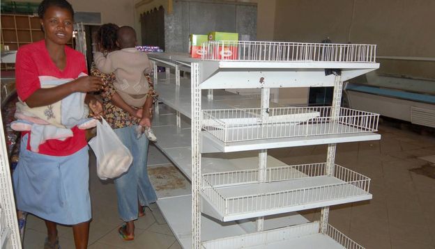 JULY 4th 2007: Zimbabwean shoppers walk past empty shelves in Mabvuku, Harare, Zimbabwe. Zimbabwe's government ordered shop owners to reduce prices on all goods by 50% which has resulted in an acute shortage of most basic commodities. President Robert Mugabe has accused businesses of profiteering and working in cahoots with the country's enemies to incite people to revolt against his government.
