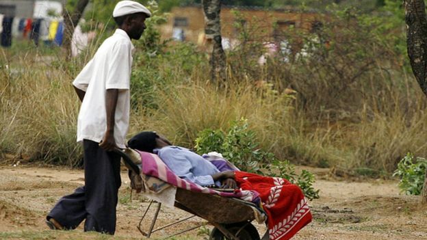 A man pushes his relative in a wheelbarrow to a cholera clinic in Harare, Zimbabwe (05 November 2008)